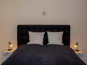 ein Schlafzimmer mit einem schwarzen Bett mit zwei Lampen in der Unterkunft 146 Südstrand Meerblick in Wilhelmshaven