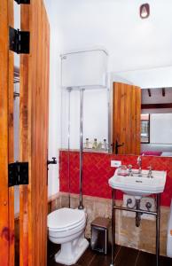 La salle de bains est pourvue de toilettes et d'un lavabo. dans l'établissement Hotel Casona Usaquen, à Bogotá