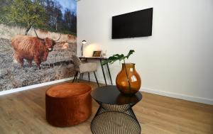 een woonkamer met een tafel en een vaas aan de muur bij Hotel Brasserie de Kaai in Steenbergen