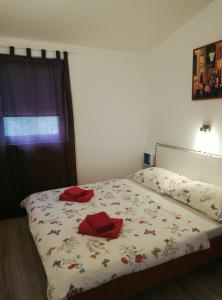 um quarto com uma cama com duas toalhas vermelhas em Apartment Anita em Fažana