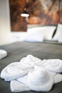 a pile of towels sitting on top of a bed at Marusius Apartmanház in Makó