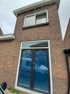 una ventana en el lateral de un edificio de ladrillo en Appartement DELUXE, en Tilburg