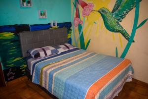 a bedroom with a bed with a painting on the wall at Passion Hostel - Barranco in Lima