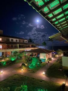 a view of a courtyard at night with the moon at Itacimirim boulevard in Itacimirim