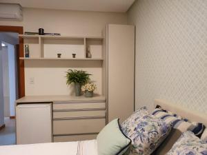 a bedroom with a bed and a kitchen with a cabinet at Itacimirim boulevard in Itacimirim