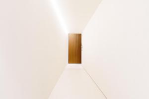 un pasillo con una puerta de madera en una pared blanca en Meo Design Suites & Spa, en Catania