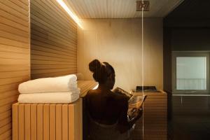 a woman reading a magazine in a sauna at Meo Design Suites & Spa in Catania