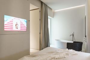 a bedroom with a bed and a tv on a wall at Meo Design Suites & Spa in Catania