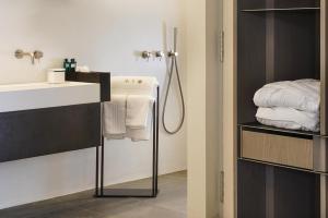 a bathroom with a sink and a shower with towels at Meo Design Suites & Spa in Catania