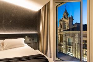 a bedroom with a window with a view of a building at Meo Design Suites & Spa in Catania