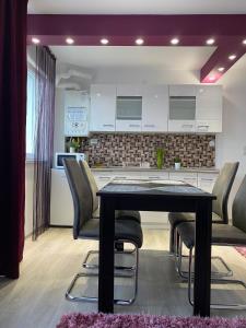 a dining room with a table and chairs in a kitchen at 12 RESIDENCE APARTMENT in Cavnic