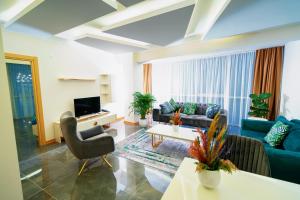 a living room with a couch and a tv at Continent Luxury Suites Sakarya in Sakarya