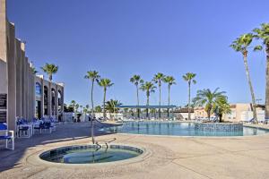 a swimming pool at a resort with palm trees at Long Island Village Escape with Deck and Pool Access! in Port Isabel