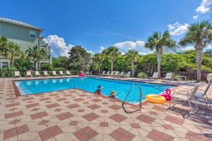 a swimming pool with two children playing in it at Bright and Modern Townhome Steps to Miramar Beach! in Destin