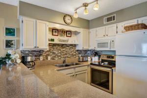 cocina con armarios blancos y encimera en Crystal Sands III, en Destin