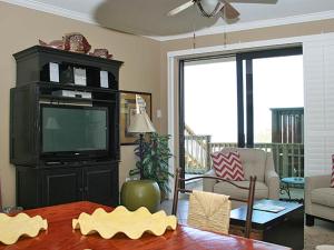 a living room with a tv and a table at Mainsail I in Destin