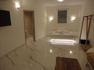 a white room with a bed and a mirror at Triena Apartments in Fira