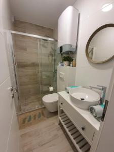 een badkamer met een toilet, een wastafel en een spiegel bij Viva Zadar in Zadar