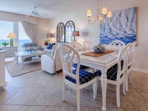 a dining room and living room with a white table and chairs at Crescent III in Destin