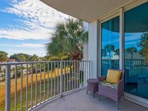 a balcony with a chair and a view of the ocean at The Palms of Destin in Destin