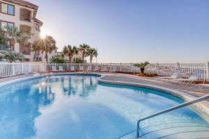 a swimming pool with chairs and a building at Windancer Condominiums in Destin