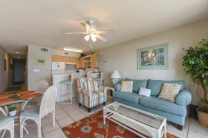 a living room with a blue couch and a kitchen at Crystal Sands II in Destin
