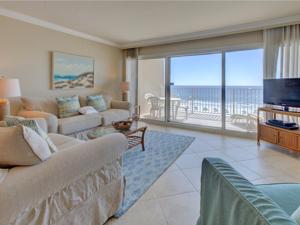 a living room with a couch and a television and a balcony at Beach House IV in Destin