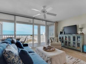 sala de estar con sofá azul y TV en Magnolia House at Destin Pointe III, en Destin