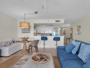 a living room with a blue couch and a kitchen at Magnolia House at Destin Pointe III in Destin