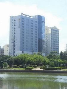 un perfil urbano con edificios altos y un cuerpo de agua en Jinjiang Inn - Hainan Haikou Dongfeng Bridge, en Haikou