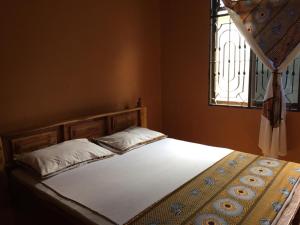 un letto in una camera da letto con finestra di BeSwahilid B & B a Bagamoyo