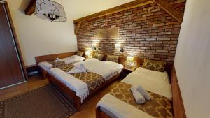 Cette chambre comprend 2 lits et un mur en briques. dans l'établissement Apartmán Marta, 200 m Ski Tatranska Lomnica, à Tatranská Lomnica