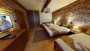 a bedroom with two beds and a brick wall at Apartmán Marta, 200 m Ski Tatranska Lomnica in Vysoke Tatry - Tatranska Lomnica.