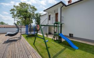 een tuin met een speeltuin met een glijbaan bij House Smoky with private pool and jacuzzi in Pazin