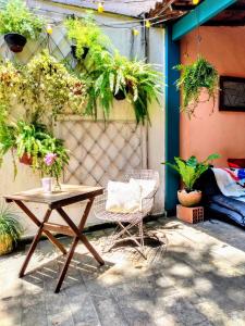 a patio with a table and a chair and plants at Hospedaria Rio in Rio de Janeiro