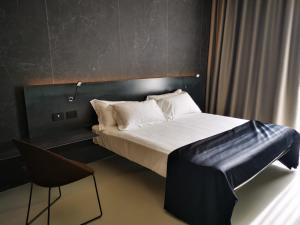 a bedroom with a large bed and a chair at Meo Design Suites & Spa in Catania