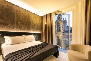 1 dormitorio con 1 cama, 1 silla y 1 ventana en Meo Design Suites & Spa en Catania