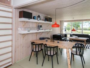 a kitchen and dining room with a wooden table and chairs at 8 person holiday home in Ebeltoft in Ebeltoft