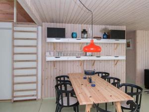 a wooden table with black chairs and a red lamp at 8 person holiday home in Ebeltoft in Ebeltoft