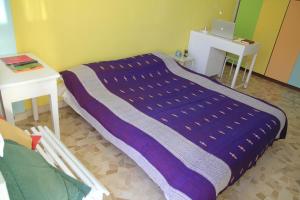 Milano: accogliente appartamento in zona comoda في ميلانو: بطانية أرجوانية على سرير في غرفة