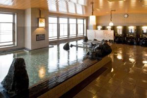 un vestíbulo con una piscina de agua con rocas. en Dormy Inn Asahikawa en Asahikawa