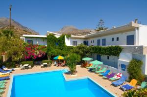 a hotel with a swimming pool with chairs and umbrellas at Costas & Chrysoula in Plakias