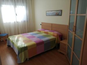 um pequeno quarto com uma cama e uma janela em Apartamento playa Cambrils edificio Torresol em Cambrils