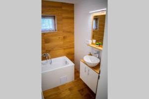 a bathroom with a white tub and a sink at Günter Vendégház-Hajdúnánás in Hajdúnánás +19 photos