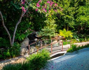 a bridge in a garden with flowers and trees at Sunset Marquis Hotel in Los Angeles