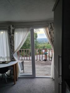 una puerta abierta con vistas a una terraza en Summer Lodge lovely big caravan in Hastings sleeps 6 free WiFi in caravan en St. Leonards