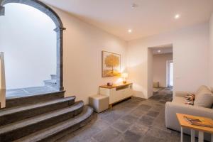 sala de estar con escalera y sofá en Casas Amarelas Azores en Ponta Delgada