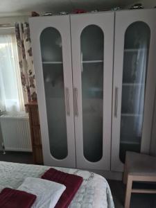 a white wardrobe with glass doors in a bedroom at Summer Lodge lovely big caravan in Hastings sleeps 6 free WiFi in caravan in St. Leonards