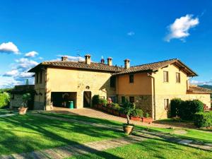 a large house with a green lawn in front of it at Agriturismo Comparone Casavecchia in Città di Castello