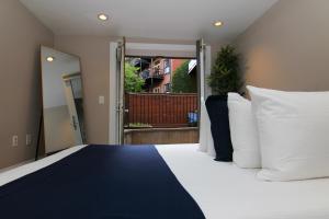 1 dormitorio con 1 cama grande con almohadas blancas en Stylish 2 Bedroom in South End, en Boston